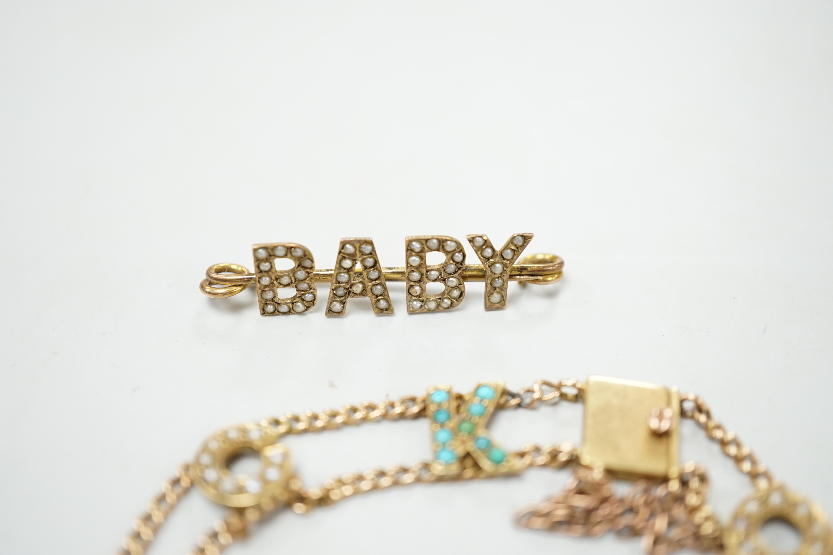 An Edwardian 15ct?, turquoise and seed pearl set 'Good Luck' chain bracelet, 17cm and a yellow metal and seed pearl set 'Baby' bar brooch.